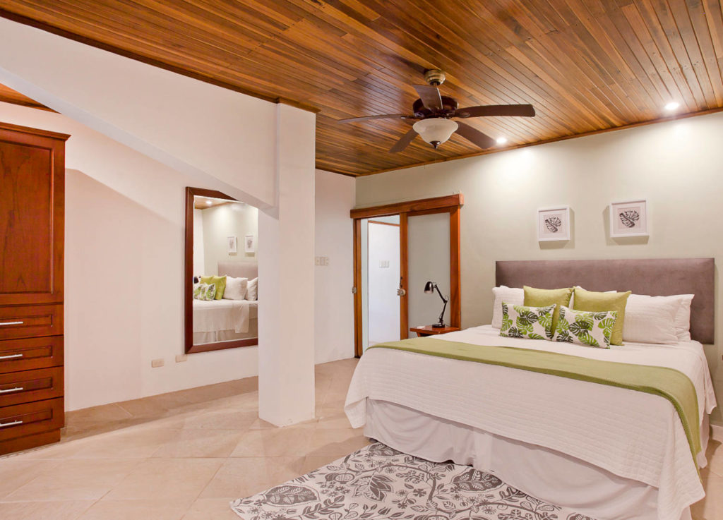 This large bedroom with king bed in the main house has a beautiful tiled floor and wood ceiling.