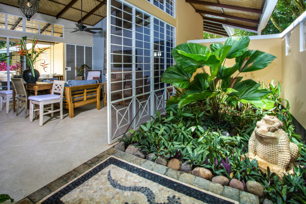 On entering the villa you are greeted by a beautiful tropical garden with a marble frog statue and impressive glass doors.