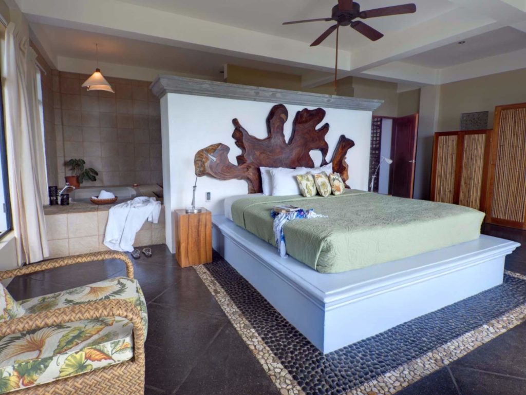 The master bedroom has a king bed with a stunning headboard of local wood, unique and natural.