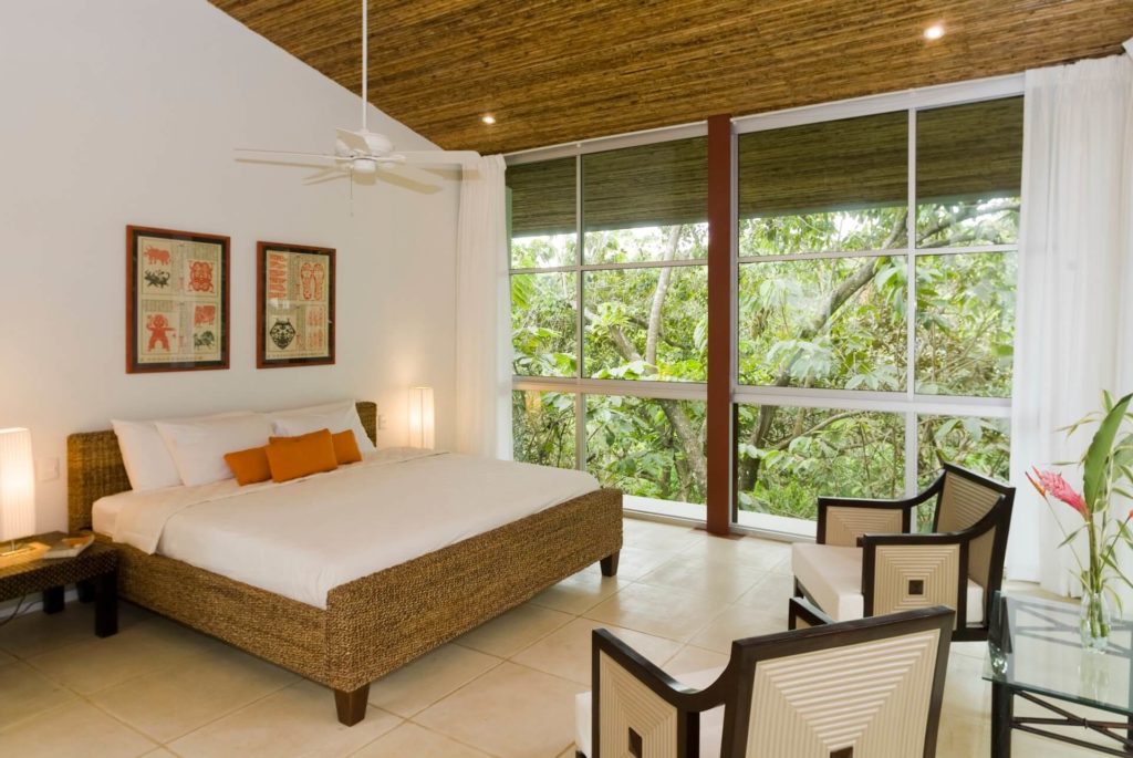 This light and inviting bedroom has a king bed and floor-to-ceiling windows that maximize the jungle views.