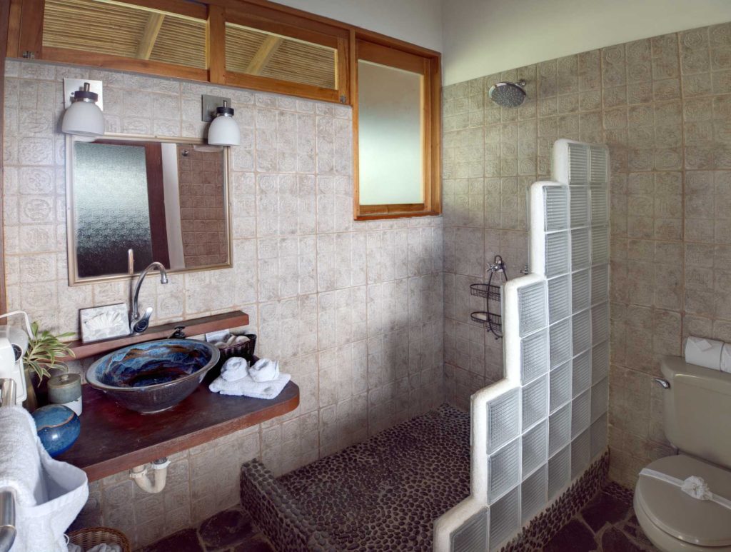 This beautiful bathroom featuring natural wood and stone serves the games room and king bedroom.