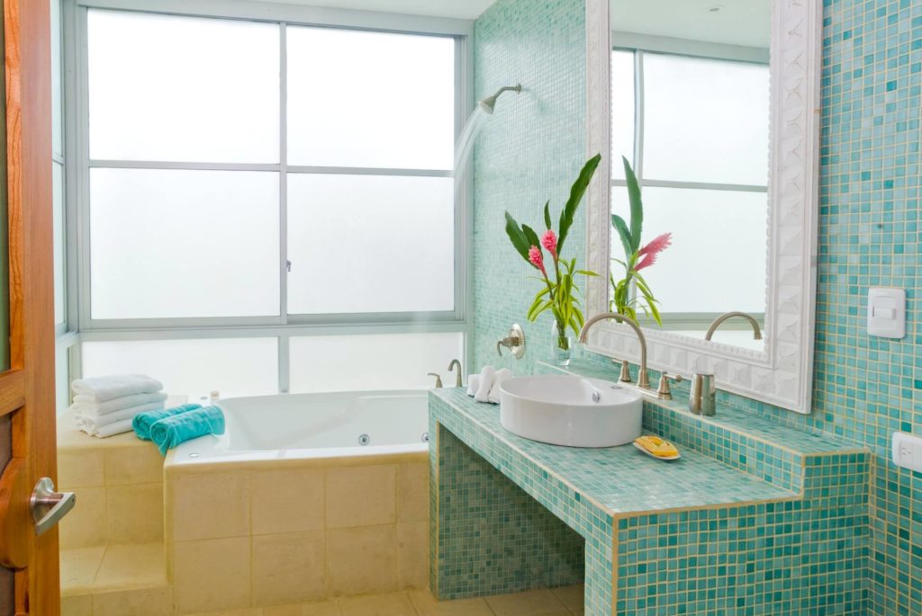 Ocean blue tiled areas add a colorful accent to this guest bathroom.