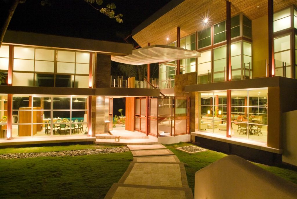 The entryway to the villa at night shows the beautiful lighting and design of this exquisite example of architecture.