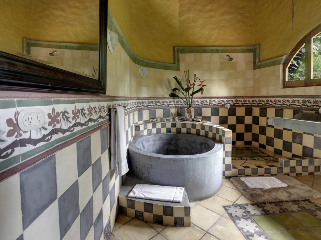 The master bathroom has exquisite tile and stone decor with a unique deep bathtub.