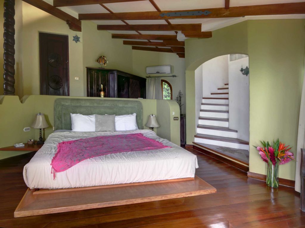 The king bed in the master bedroom faces directly towards the large glass patio doors with ocean view.