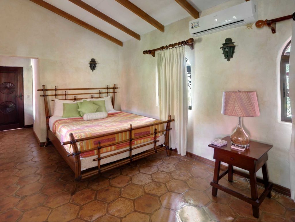 A hand-carved wooden door and a beautiful bamboo queen bed are features in the second bedroom.