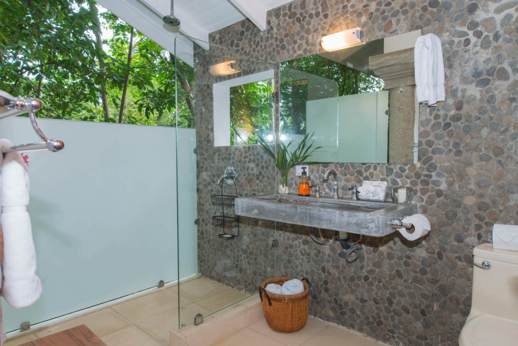 The ensuite bathroom in the separate guesthouse has an open-air jungle shower.
