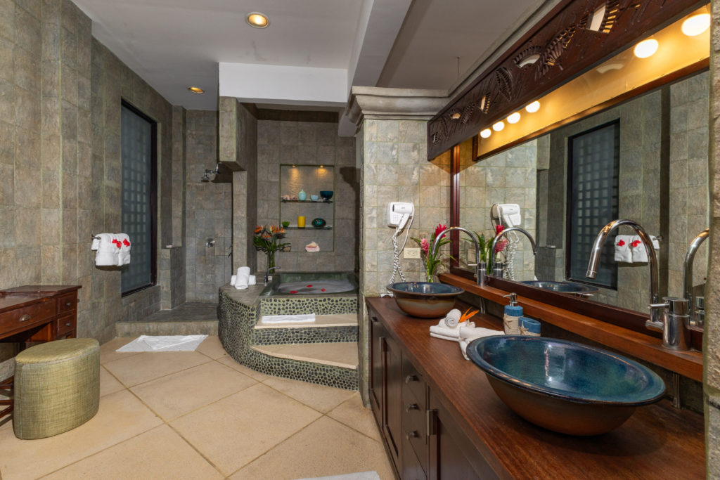 Indulge in this spacious, elegant bathroom, equipped with all the amenities for your luxury comfort, including a bathtub, double sinks, and a large shower space.