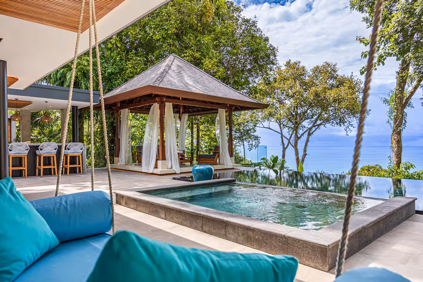 Sun loungers beside the pool with tropical jungle surroundings near Dominical, Costa Rica.
