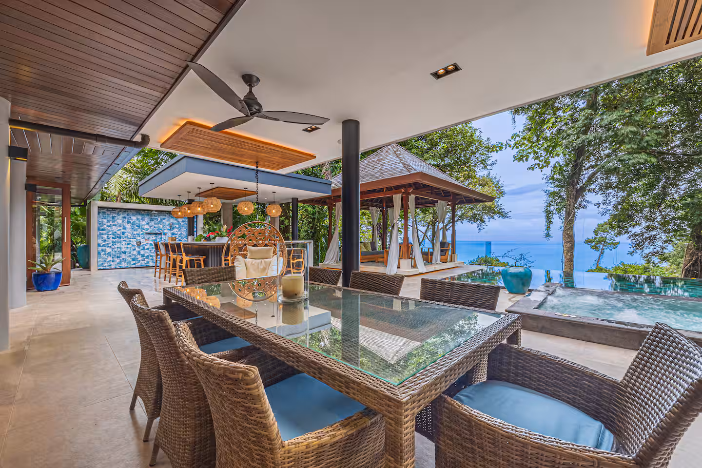 Covered outdoor dining area next to the pool with jungle and distant ocean views near Dominical, Costa Rica.