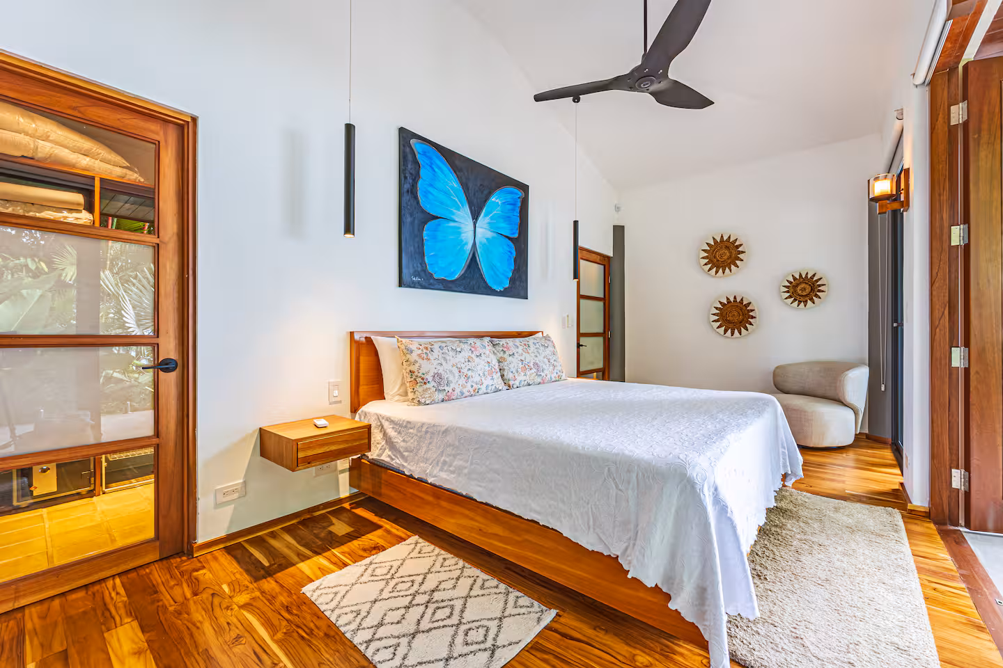 Bedroom with wood floors, artwork, and a calm atmosphere in a villa near Dominical, Costa Rica.