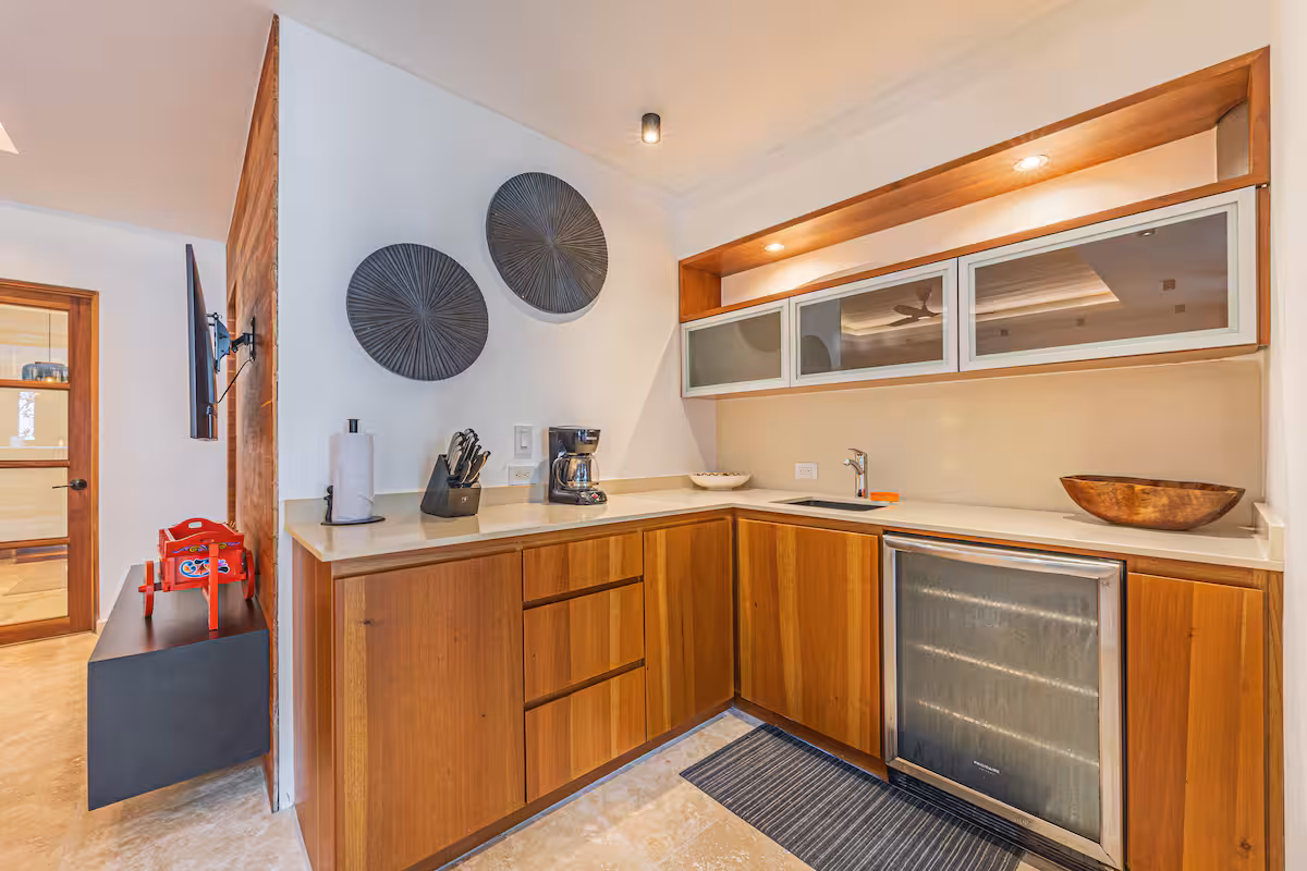 Compact kitchenette with wood cabinetry and counter space in a villa near Dominical, Costa Rica.