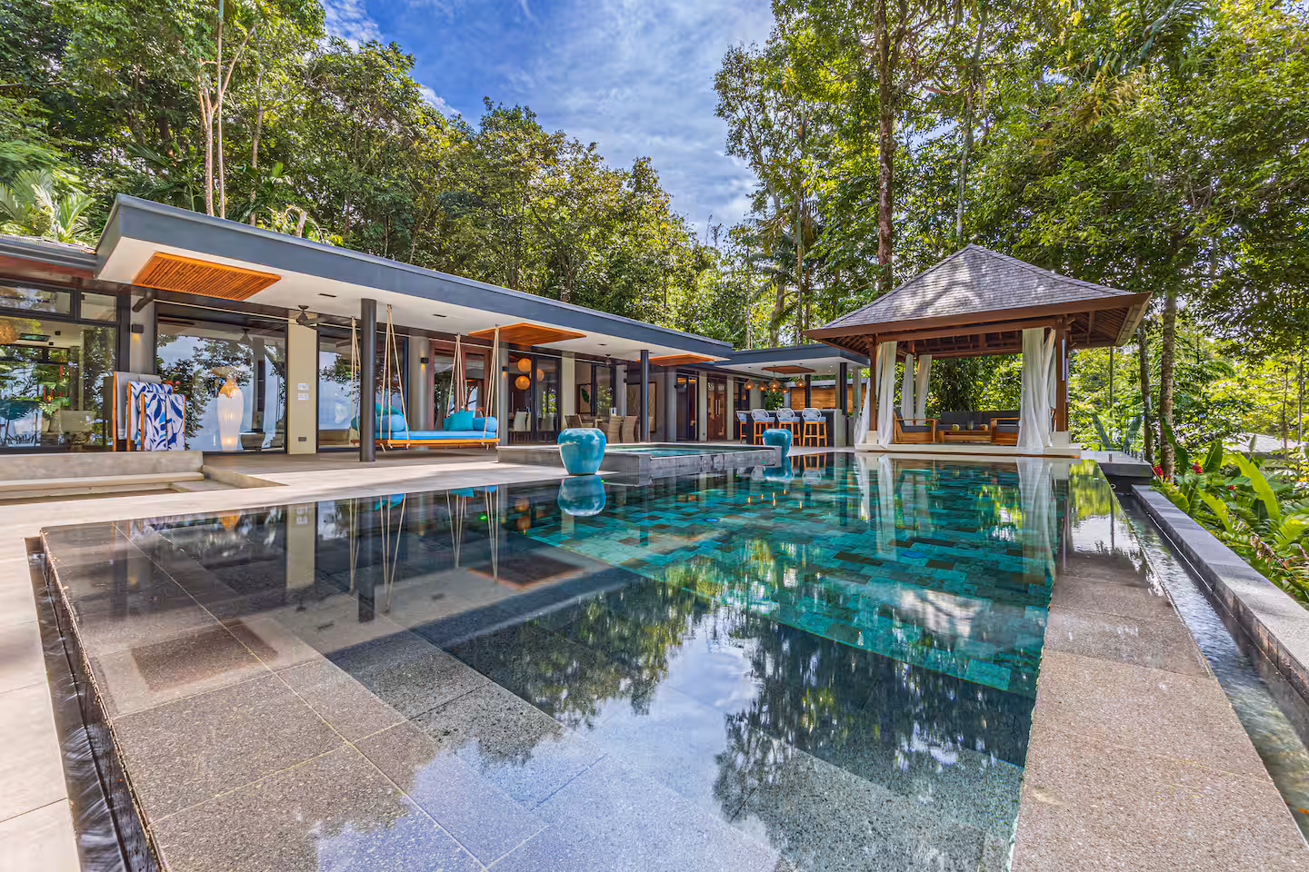 Wide view of an open-layout villa with infinity pool surrounded by tropical rainforest near Dominical, Costa Rica.