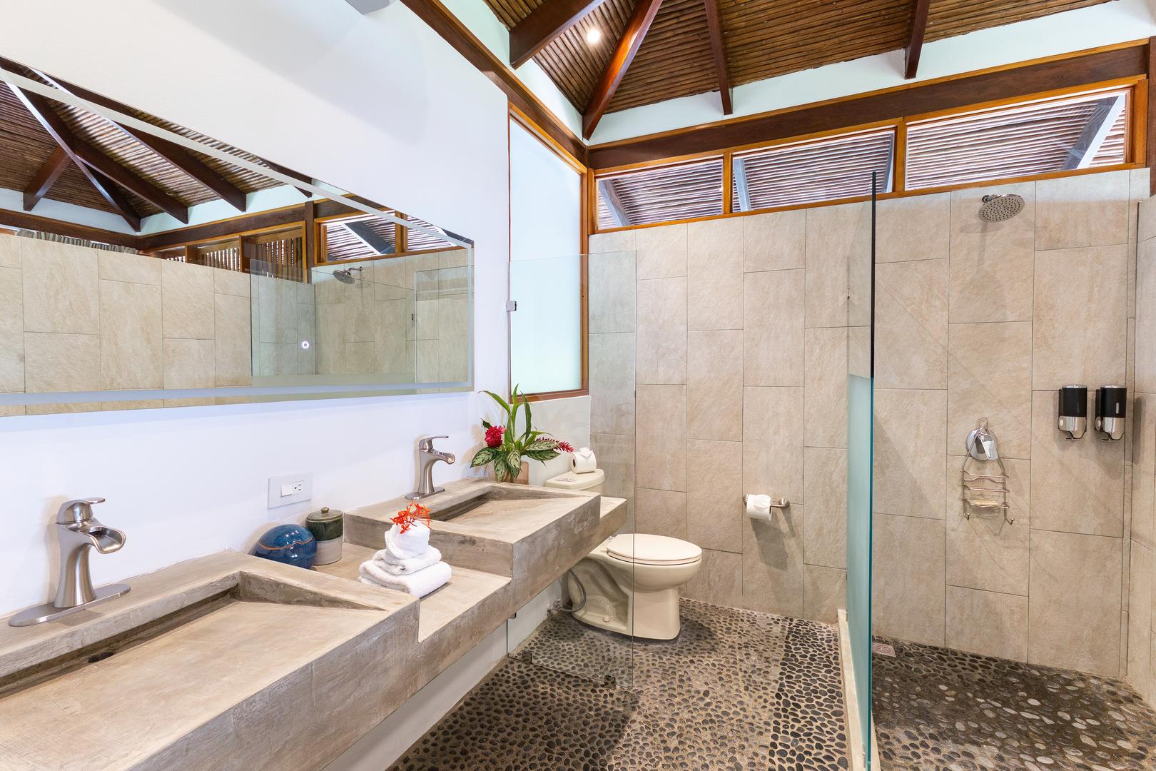 Luxury bathroom with double vanity, stone shower, and tropical architecture in Manuel Antonio