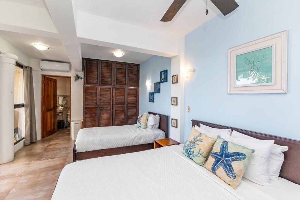 A bright twin bedroom with soft coastal colors and thoughtful details, offering a comfortable space that feels relaxed, welcoming, and easy to settle into.