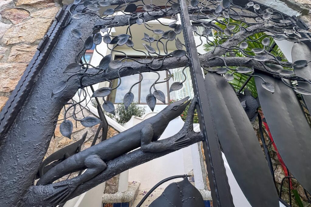 A striking custom iron gate welcomes you into the villa, where artistic craftsmanship and nature-inspired details set the tone for the experience ahead.