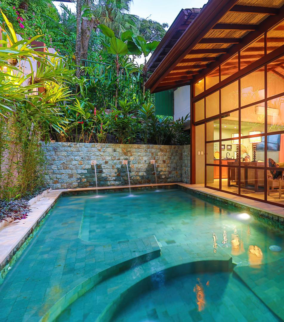 Private pool beside the new glass-walled living wing surrounded by jungle vegetation
