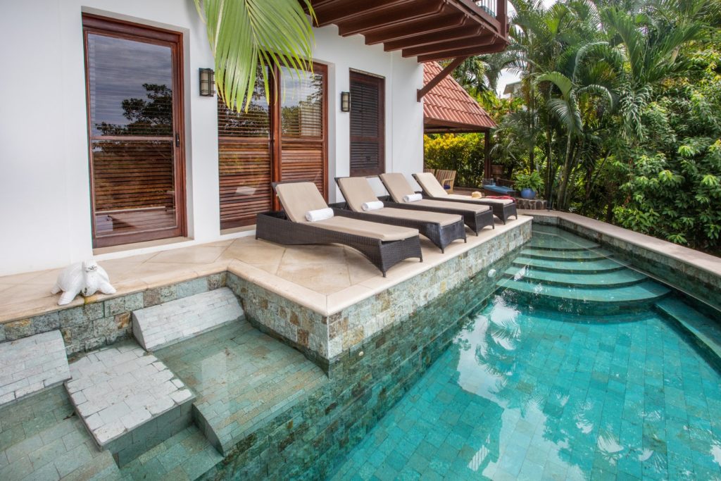 This luxury natural-stone infinity pool has recliners on the deck and underwater recliners for a cooler lounging experience.