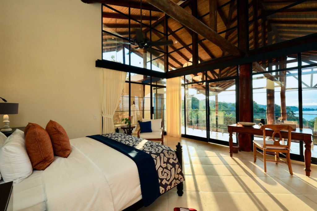 This master suite exhibits ingeniously crafted lofty ceilings with a breathtaking natural wood framework, and tall glass doors that provide sublime ocean scenery of Manuel Antonio.