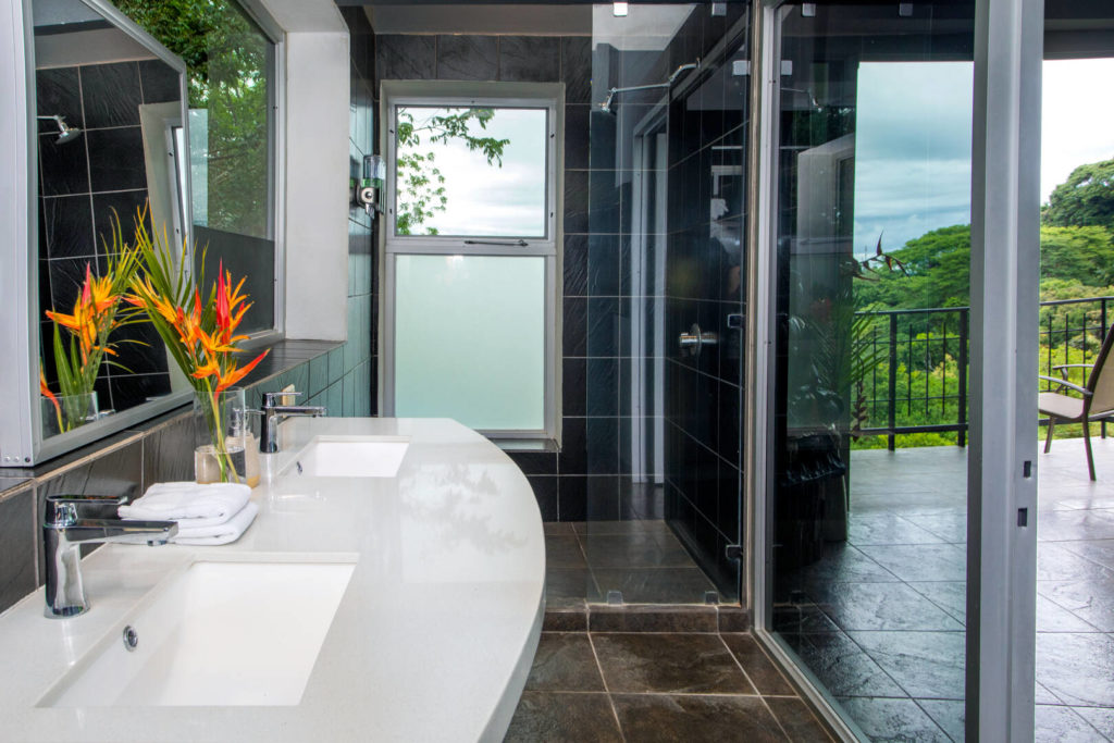 The white counter and dark tiles add a touch of class to this elegant ensuite bathroom.