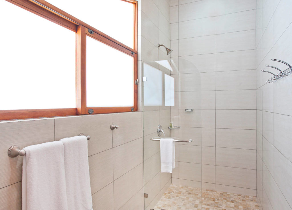 This large luxury shower is cleanly decorated with beautiful wall tiles.