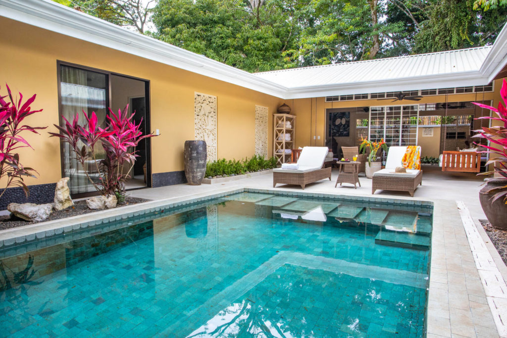 Your private pool is surrounded by vibrant tropical plants and beautifully-carved stone details.