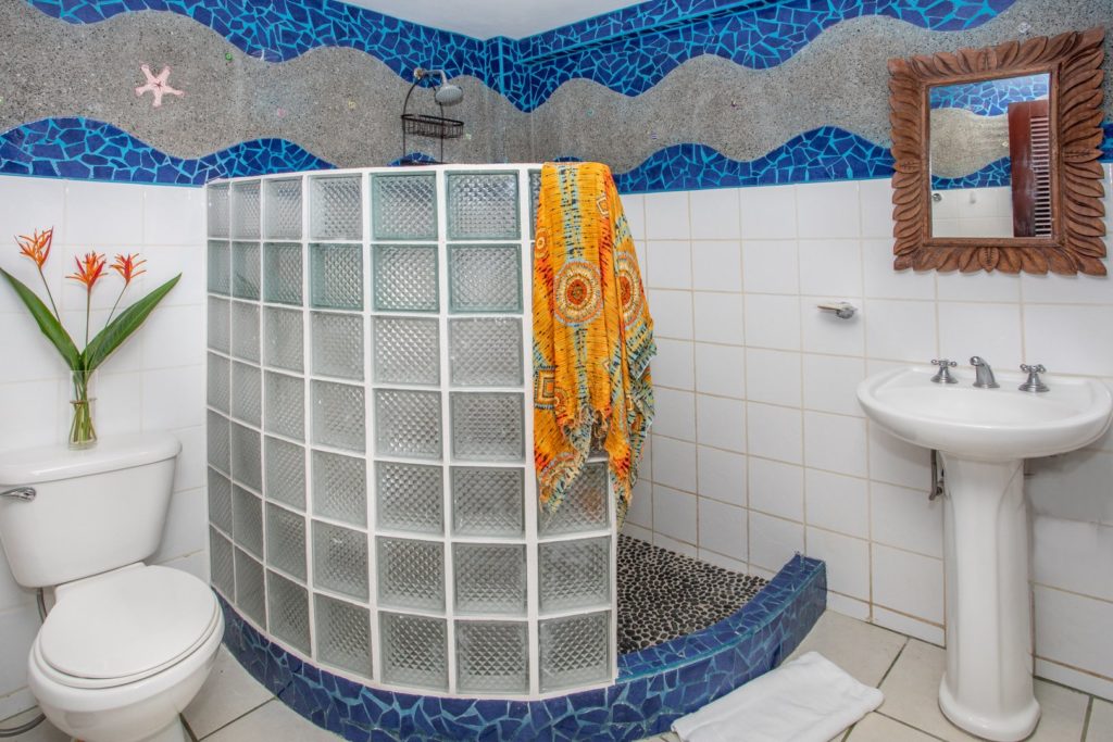 This newly-remodeled ensuite bathroom has beautiful chipped tile and a curved shower design. 