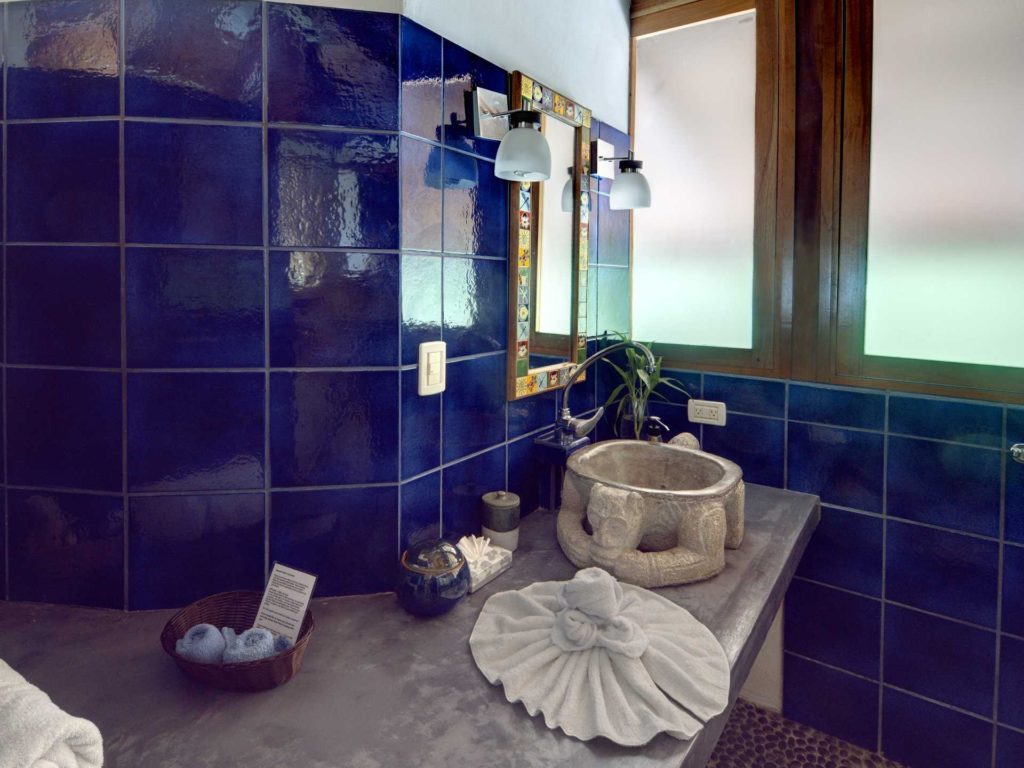 The top-level ensuite has beautiful ocean blue tiles and a carved stone monkey sink.