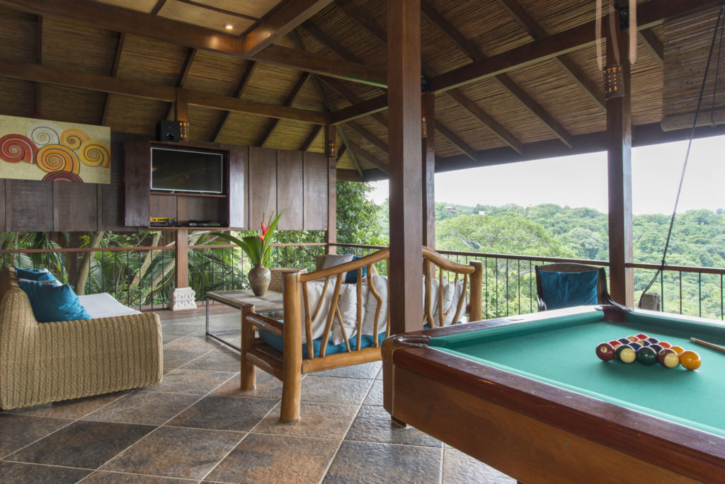 The third level features an open-air games room with pool table, TV viewing area, and full wet bar. 