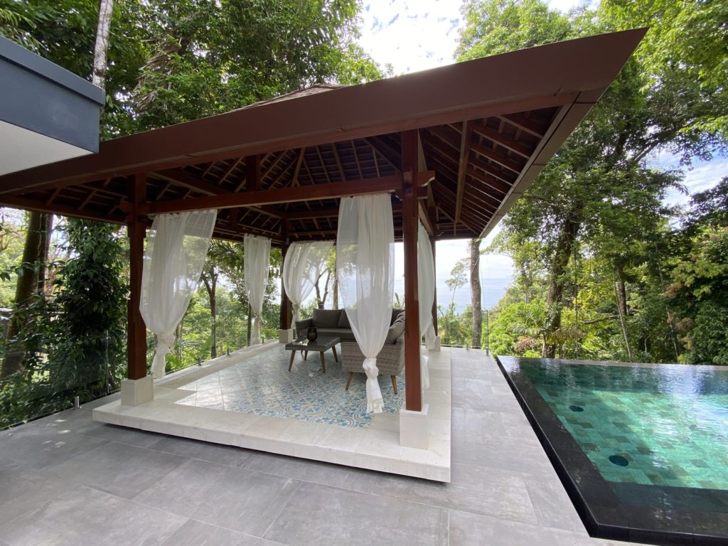 This magnificent covered seating area is right by the pool with a gorgeous view.